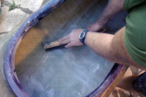 Roughing up the interior hull of the kayak with a wire brush